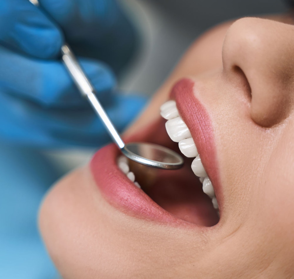 Dental patient smiling in mirror
